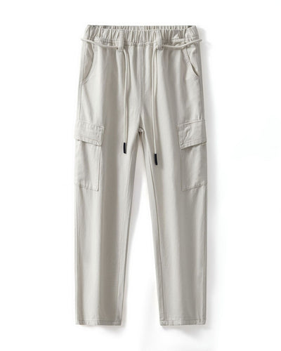 Men's beige relaxed-fit cargo pants with a drawstring waist, multiple pockets, and a modern streetwear style, ideal for casual and everyday wear.